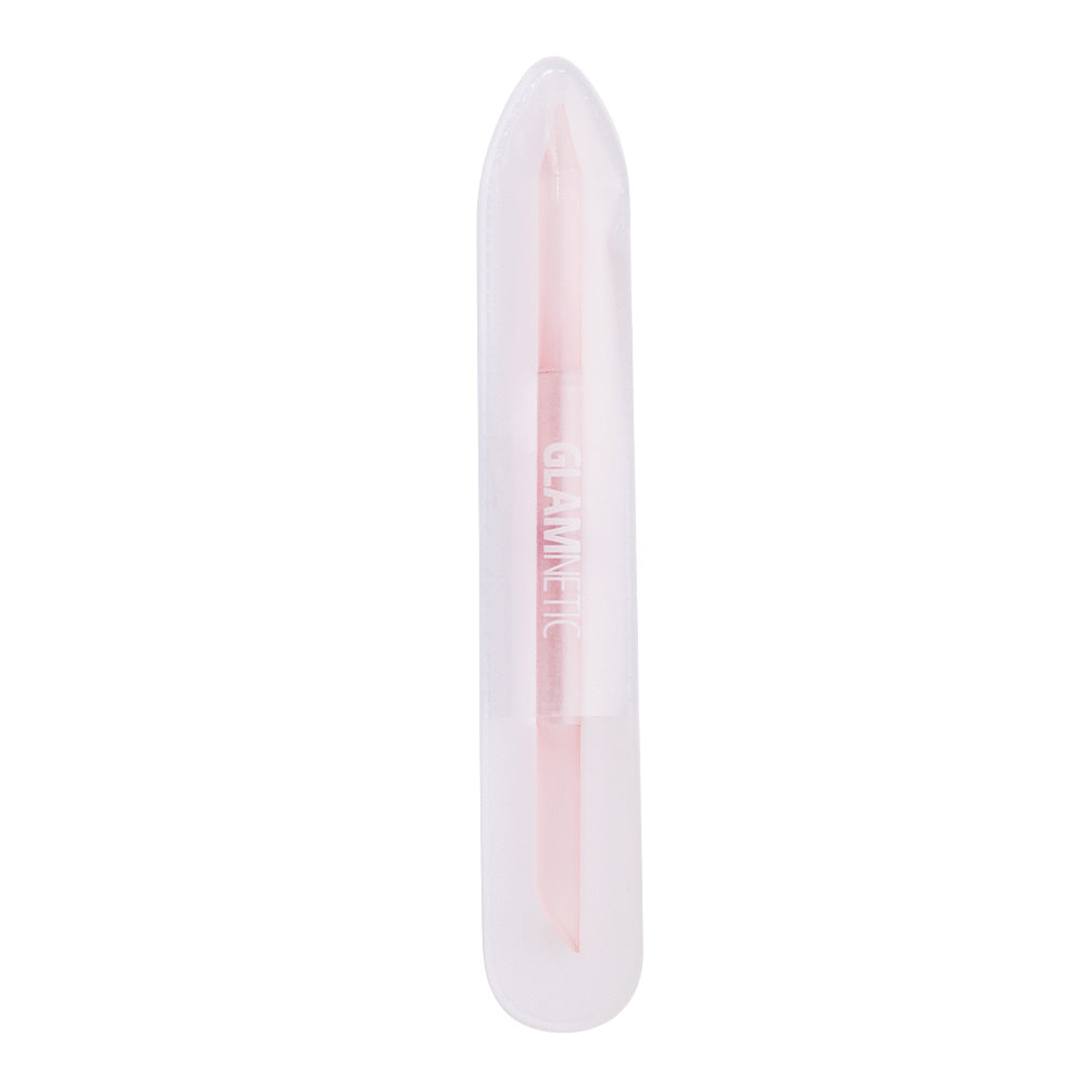 The glamnetic 2-in-1 Cuticle Pusher is a light pink tool with a pointed end for manicures and nail care, housed in a clear plastic case. GLAMNETIC is printed in white on the tool.