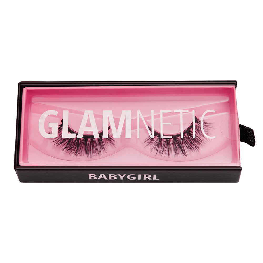 A box of glamnetic Babygirl reusable lashes with Babygirl in white text, a pink interior, and a clear lid that displays GLAMNETIC over vegan lashes.
