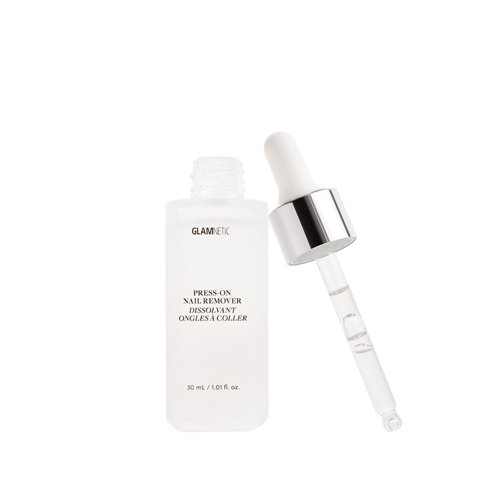 A clear bottle labeled glamnetic Press-On Nail Remover with a silver-capped dropper sits beside it. This vegan, cruelty-free, acetone-free 30 ml (1.01 fl oz) product is displayed against a clean white background.