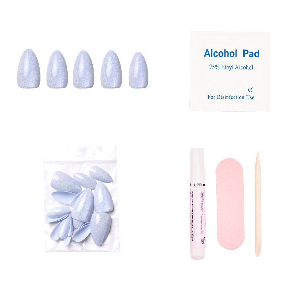 The Frozen nail set by glamnetic features light blue, short almond press-on nails. It includes an alcohol pad, extra nails, glue, a pink file, and a cuticle stick—all displayed on a white background.