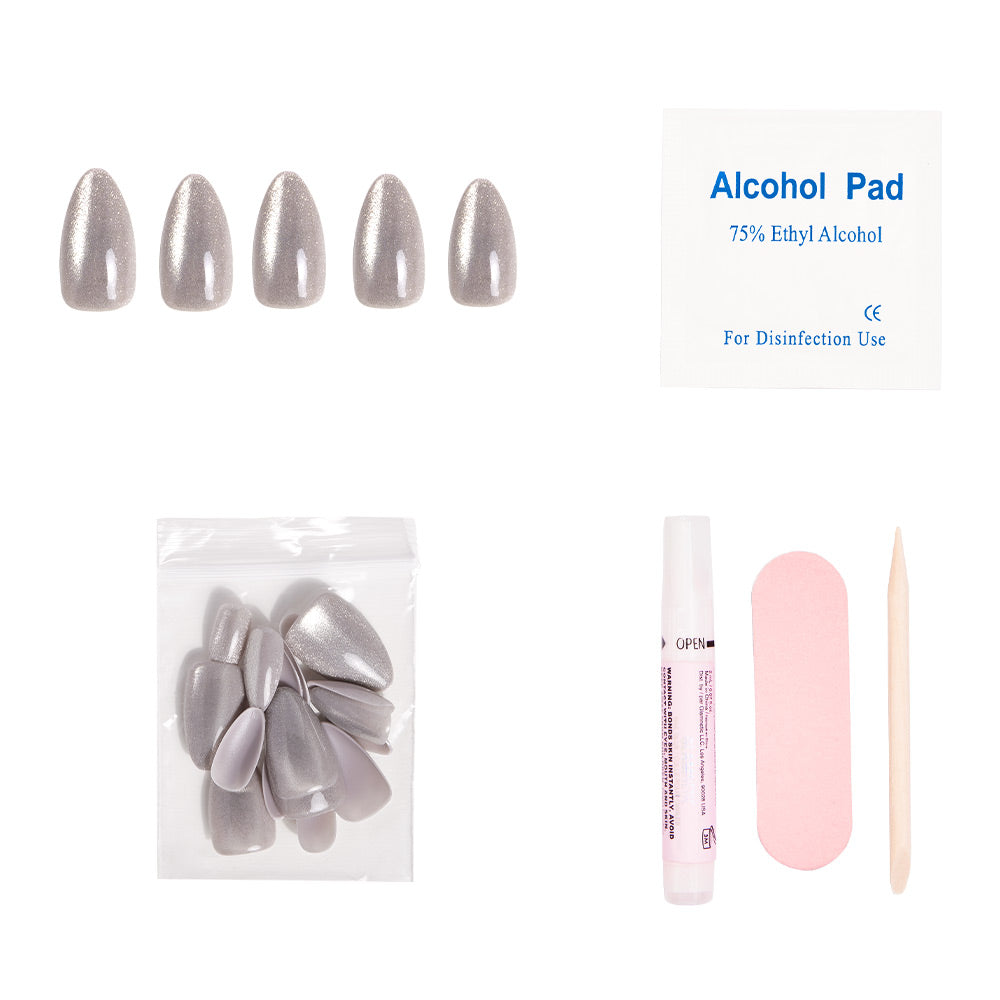 The glamnetic Oslo press-on nails kit features five short-almond, silver cat’s-eye nails, extra nails, an alcohol pad, nail glue tube, a pink nail file, and a wooden cuticle stick—all displayed on a white background.