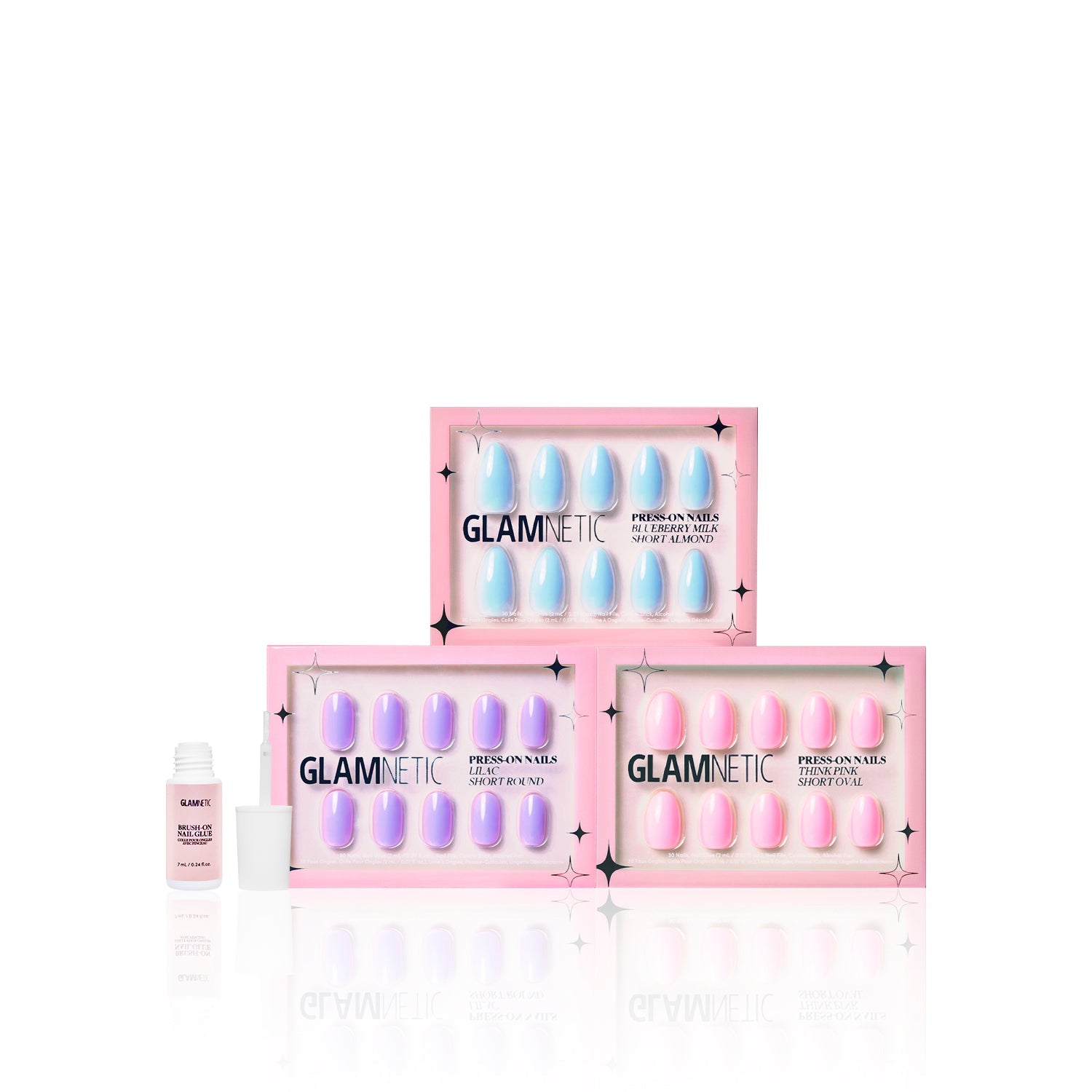 Three boxes of glamnetic Blooming Buds press-on nails are stacked in a pyramid, with a small bottle of nail glue on the left, all set against a white background.