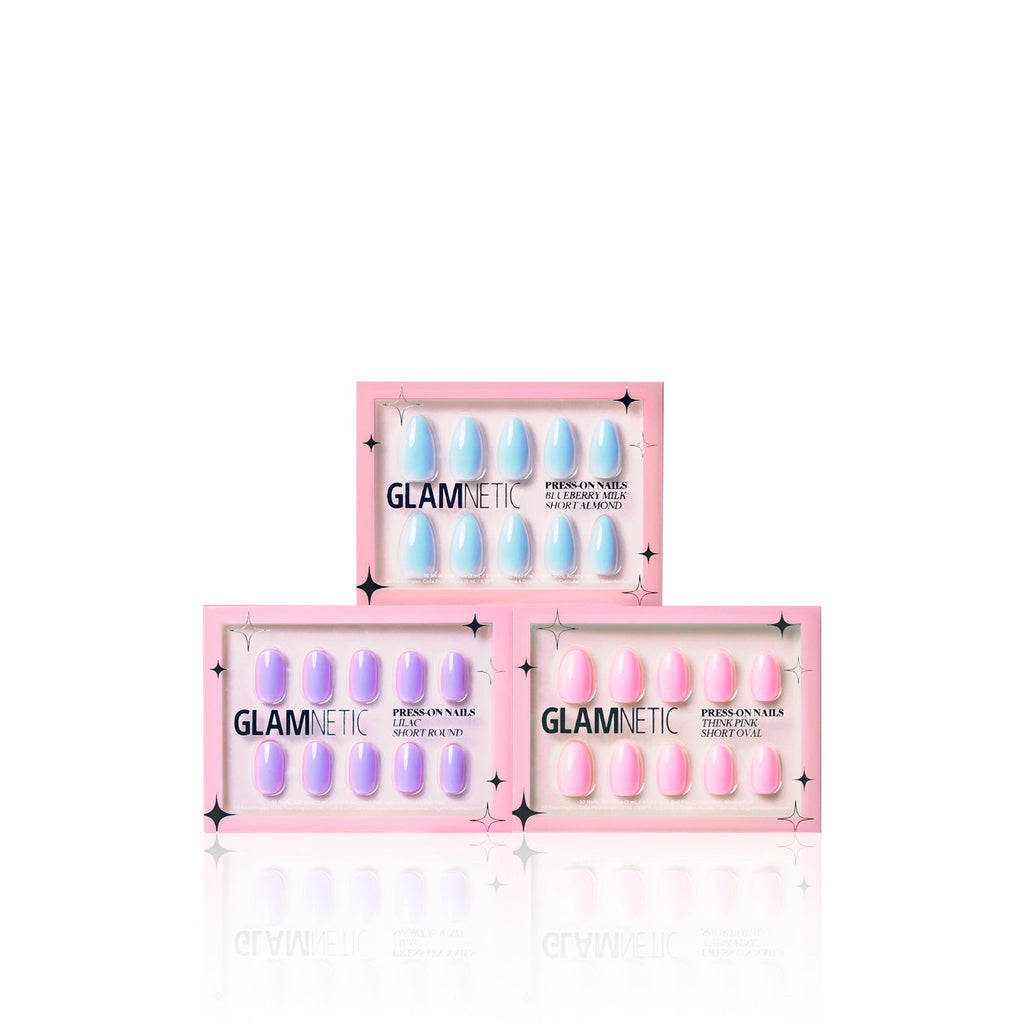 Three boxes of glamnetic Blooming Buds press-on nails are stacked in a triangle. Each box features a pink border and clear windows, revealing pastel shades for a playful pop of color.