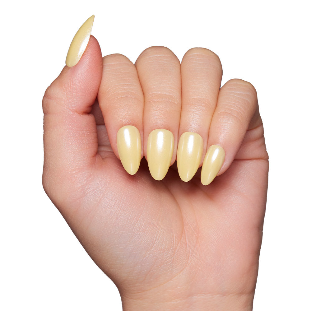 A hand with light skin tone showcases long, almond-shaped, glossy pastel yellow nails using the glamnetic Yellow Pop press-on nail set, displayed against a white background.