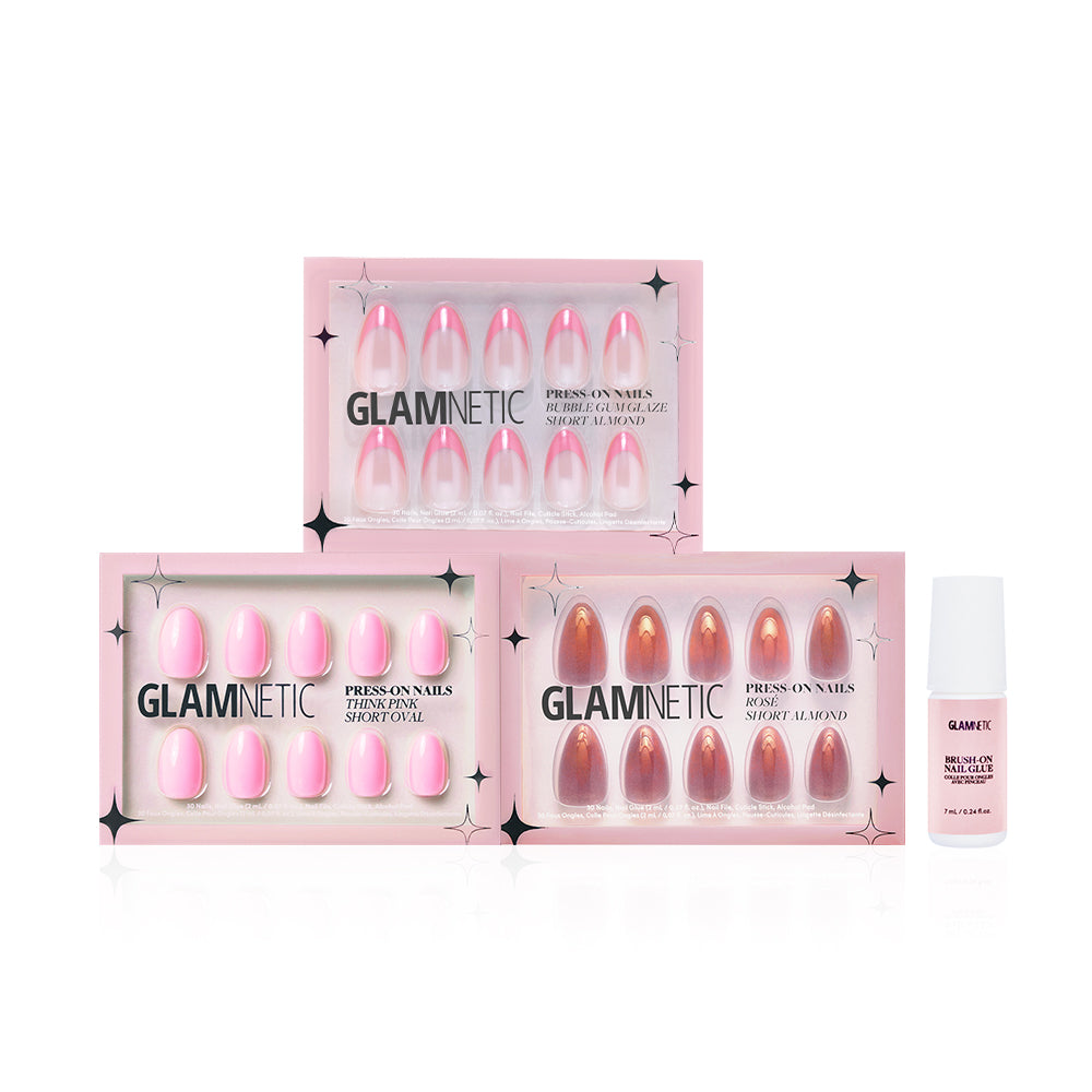Three pink and nude-toned glamnetic press-on nail sets, including Blush Crush, arranged in staggered rectangular boxes alongside a small white bottle of glamnetic nail glue.