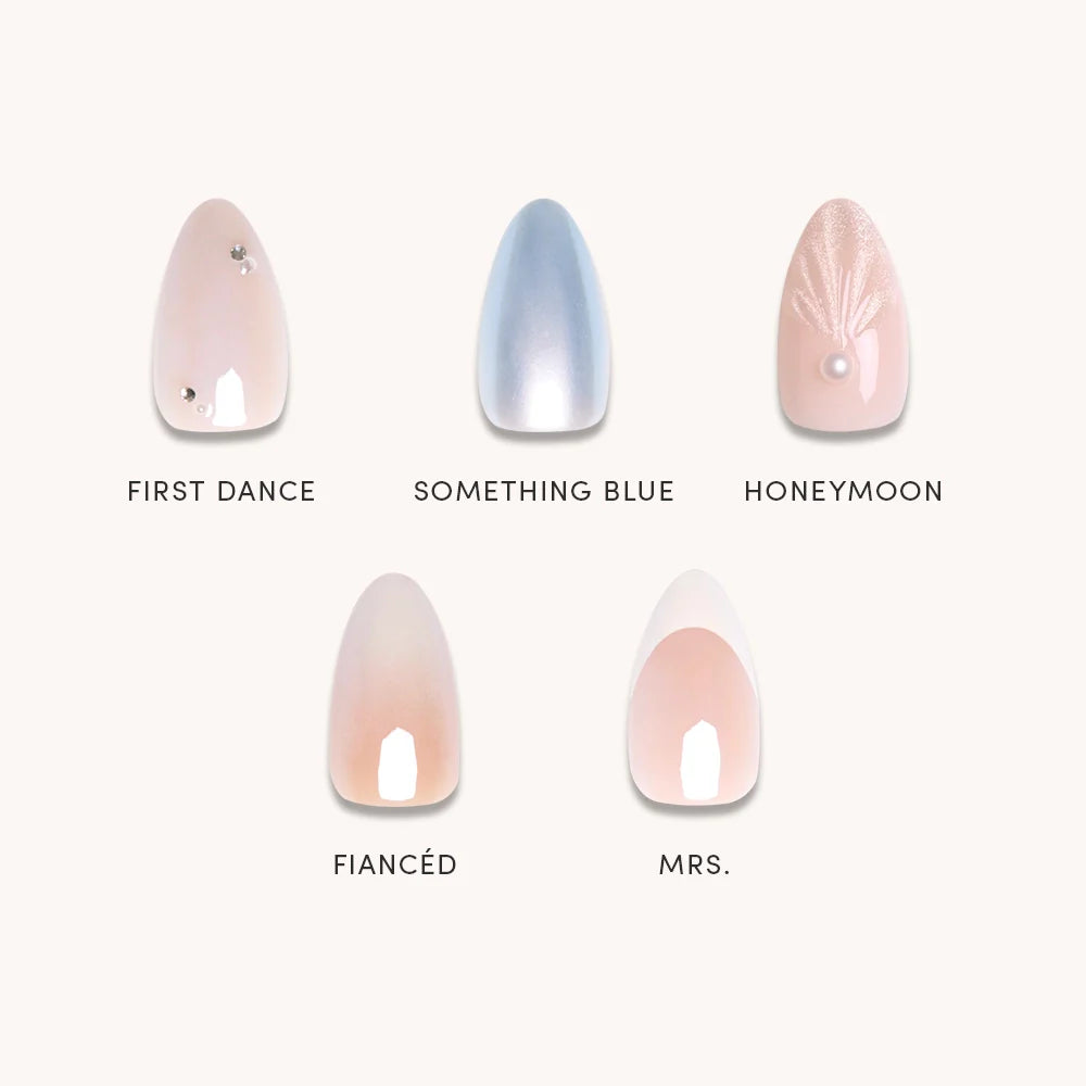 Anns Bridal Edit by glamnetic features five press-on nails—First Dance (pale pink with gems), Something Blue (shimmery blue), Honeymoon, Fiancé, and Mrs. (nude French tips)—perfect for any wedding celebration.