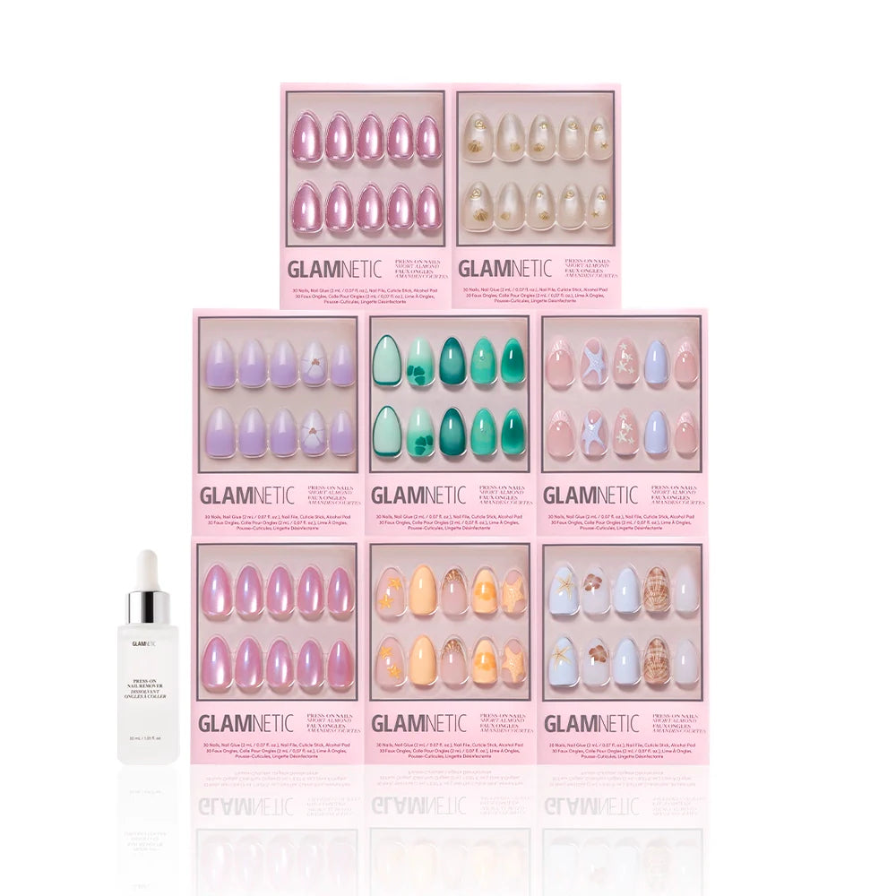 Eight boxes of Glamnetic Almonds At Sea press-ons in pastel colors and 3D starfish accents are stacked together, with a small white dropper bottle on the left, all set against a white background.