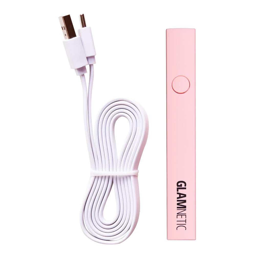 A pink rectangular Handheld UV LED Lamp from glamnetic is shown beside a coiled white USB charging cable with dual connectors.