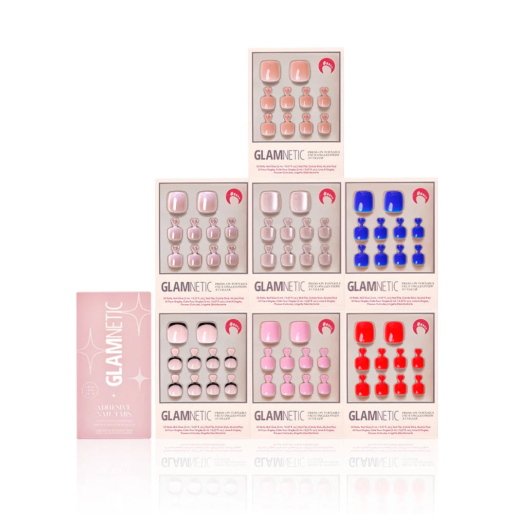 Bright & Light Hues Pedi Bundle from Glamnetic displayed with a pink box of adhesive nail tabs. Includes seven press-on toenail kits in assorted shades such as blue, red, pink, and nude, presented in a symmetrical layout