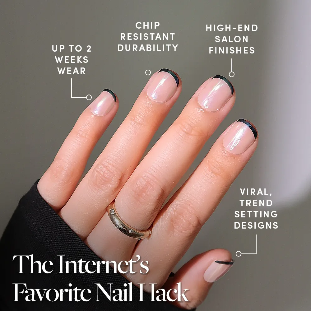 A hand with short, almond-shaped nails in glamnetic’s Burnt Miso, featuring minimalist black French tips and a glossy glazed finish. Enjoy up to 2 weeks wear, chip-resistant durability, salon-quality shine, and viral trendsetting style.