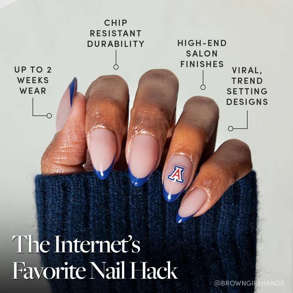 A hand with long almond-shaped nails, featuring navy French tips and an A logo accent, showcases the glamnetic Arizona Wildcats Press-On Nail Set—durable, chip-resistant, salon-quality press-ons with trendy two-week wear.