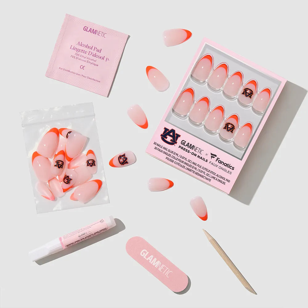 The glamnetic Auburn Tigers Press-On Nail Set includes orange-tipped nails with team logo art, nail glue, an alcohol pad, nail file, cuticle stick, and extra nails—all displayed on a white background.