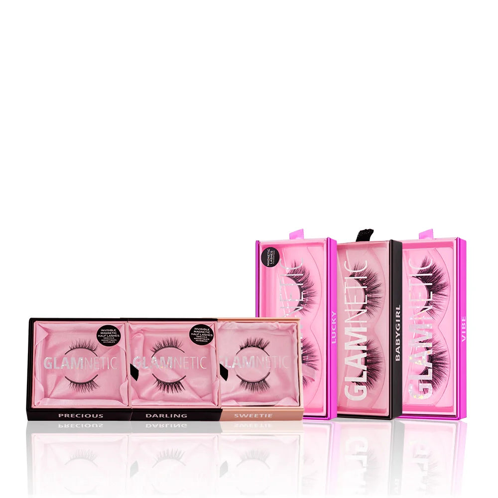 Three pink rectangular glamnetic Lash Out Loud boxes are displayed side by side, with three more standing upright behind them. Each box has reusable lashes in unique styles, including dramatic cat-eye lashes.