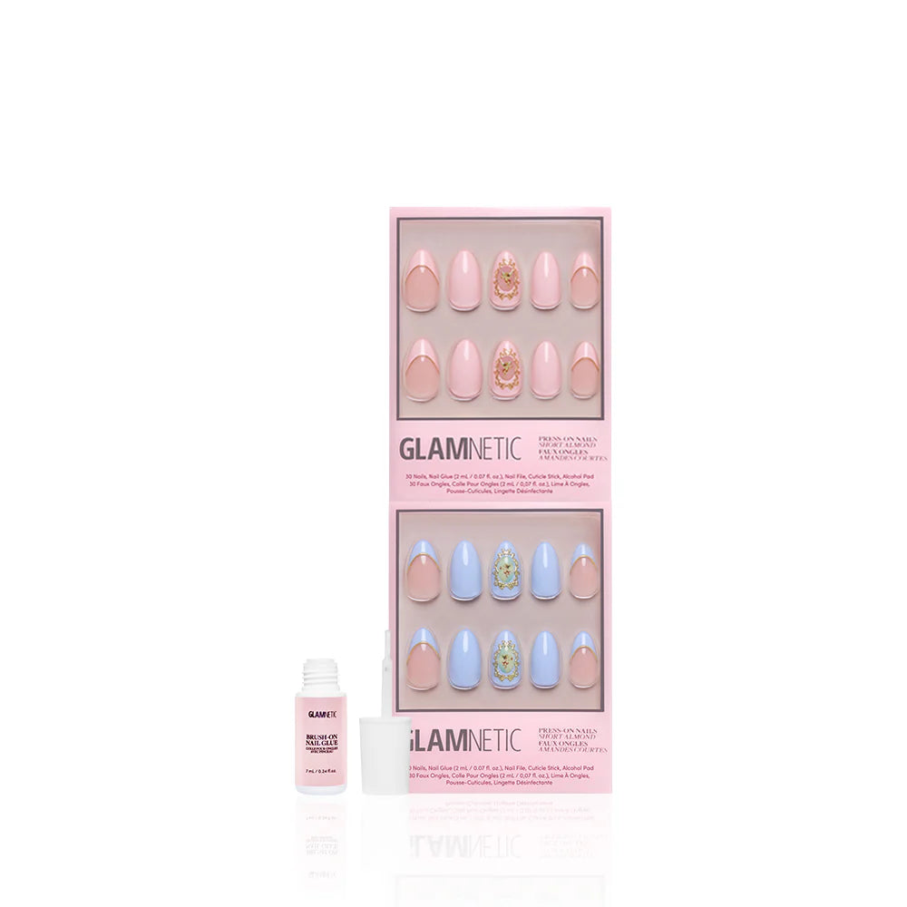 A boxed set of glamnetic Heaven Sent almond press-on nails in pastel pink and blue, featuring 3D gold accent details. An open bottle of nail glue is placed in front of the package.