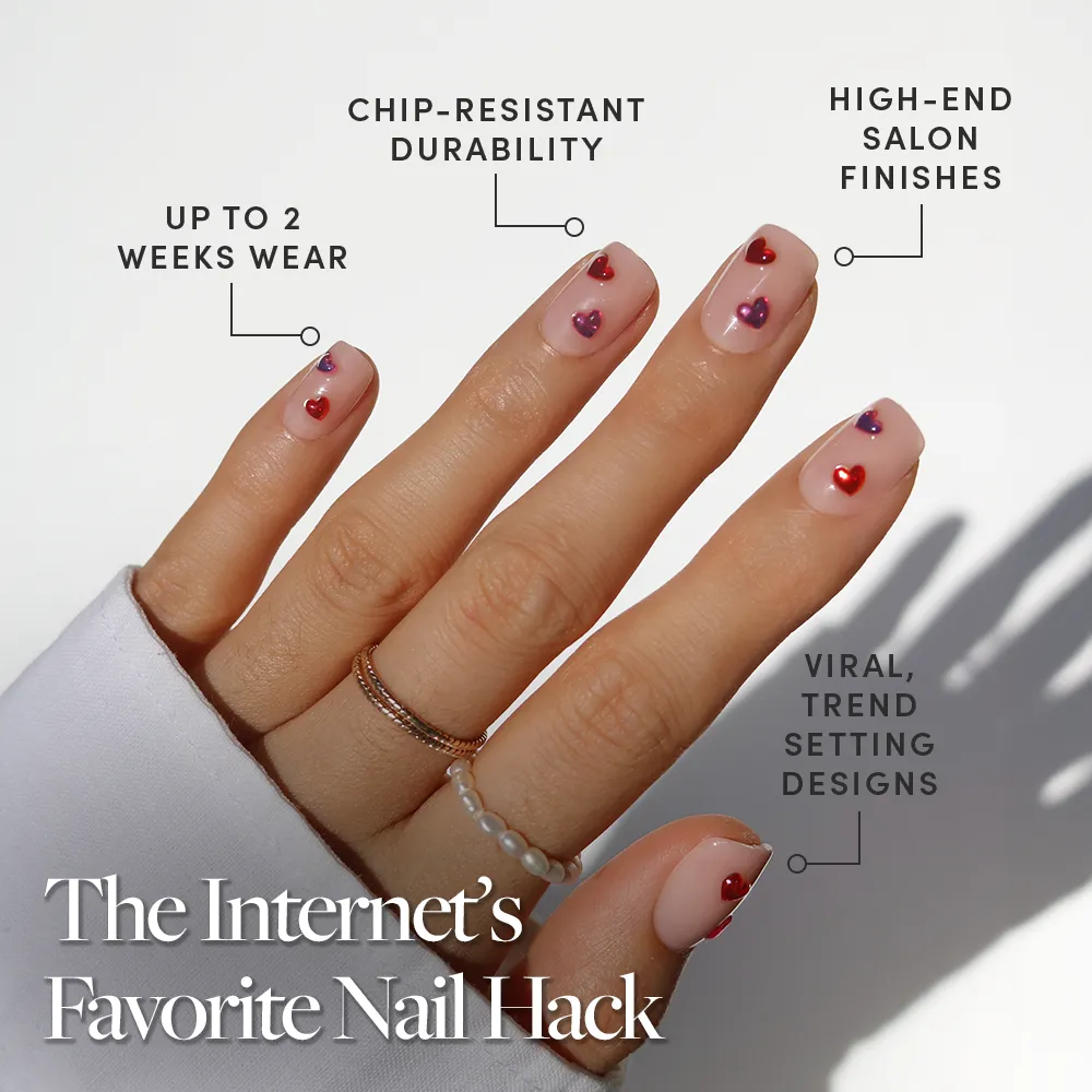 A hand with manicured short squoval nails in the Dear Lover style by glamnetic is shown, featuring colorful heart designs. Benefits include up to 2 weeks wear, chip-resistant durability, high-end finishes, and trendy viral looks.