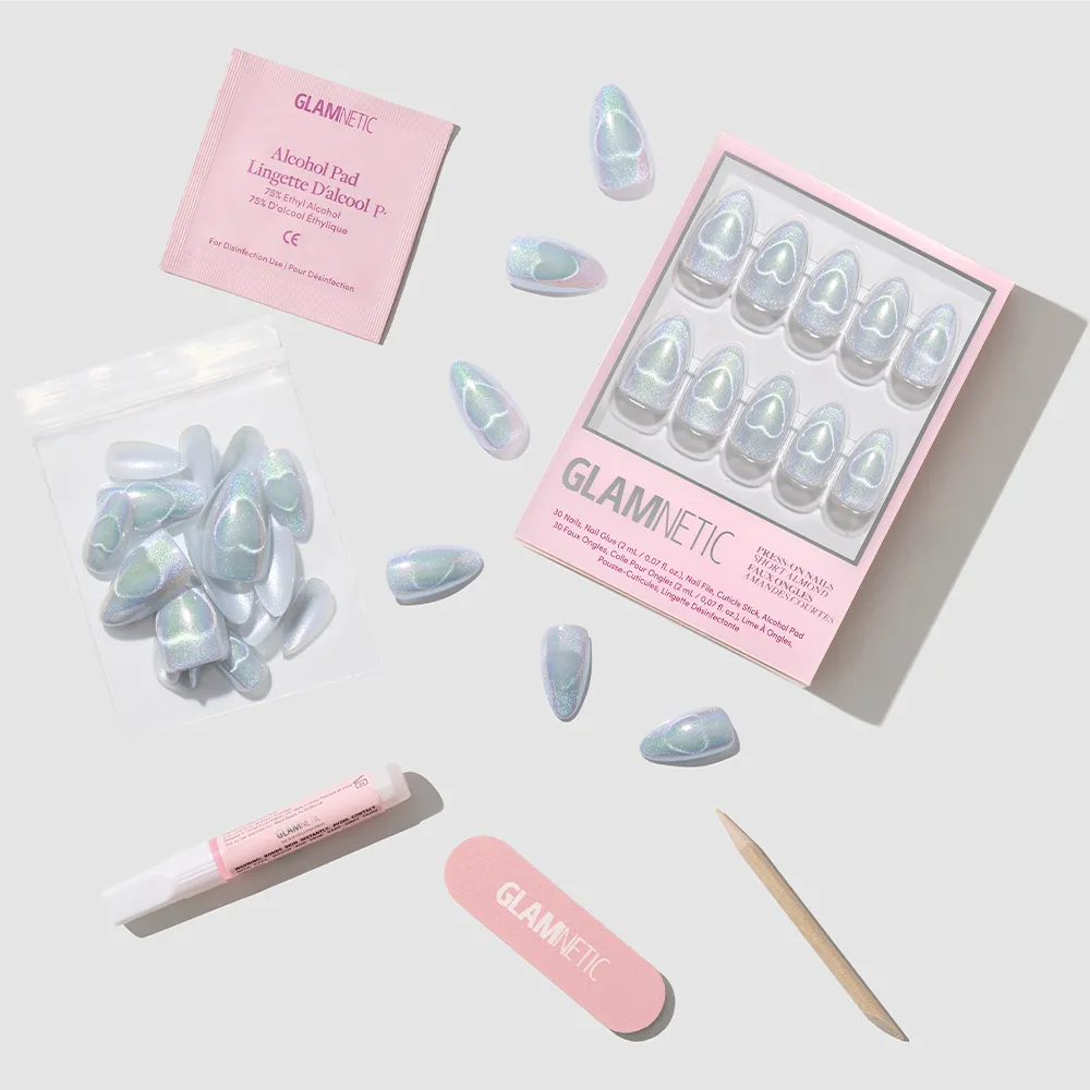 The Electric Lover set by glamnetic features iridescent, holographic nails with extra nails, a nail file, cuticle stick, nail glue, and alcohol pad on a light gray background. Both the packaging and nail file display the glamnetic logo in pink.