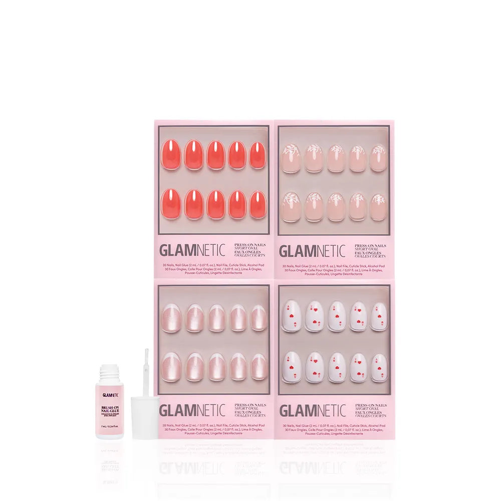 Four sets of glamnetic's The Oval Affair press-on nails in pink packaging showcase soft-luxury, classic oval designs in pink and coral. A nail glue with brush sits on the left, all on a white background.
