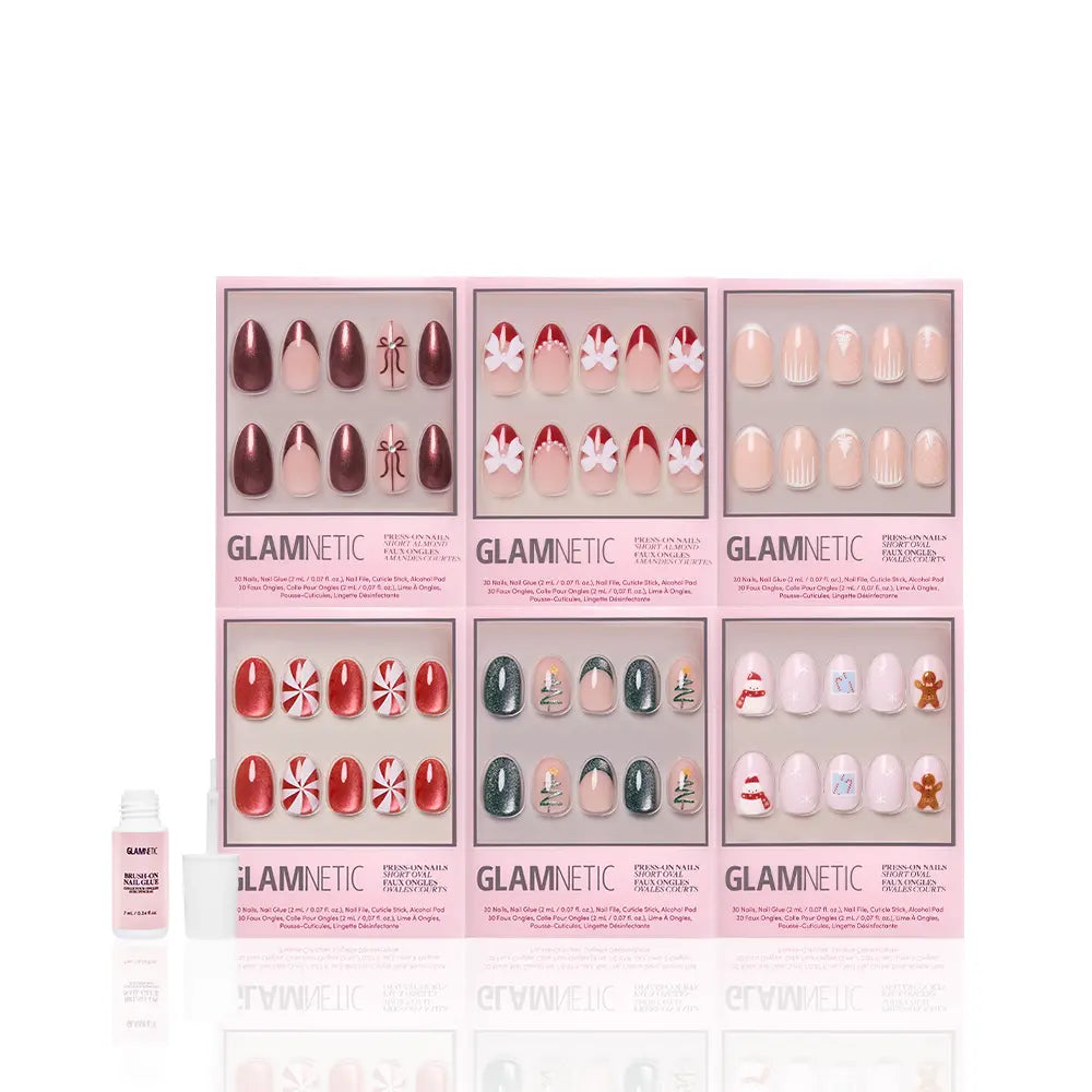 Get "All Decked Out" by glamnetic: six festive winter press-on nail sets in pink boxes, featuring holiday designs like candy canes, snowflakes, gingerbread men, classic red, and nude—plus nail glue included!.