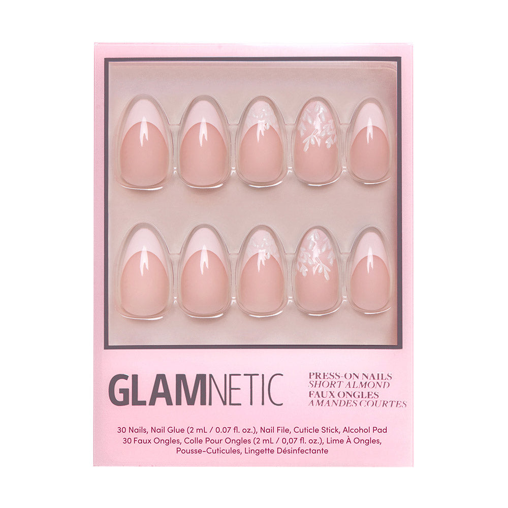 A box of glamnetic All Time Love short almond nails in pink, with white floral designs and subtle French tips. Packaged in pink with product details at the bottom. All nails are vegan and cruelty-free.