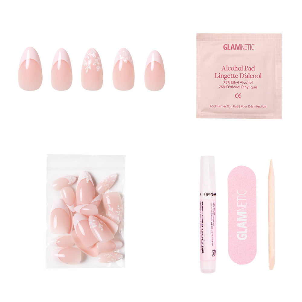 The glamnetic All Time Love set features vegan, cruelty-free pink press-on nails with floral designs and French tips, plus an alcohol pad, extra nails, nail glue, a pink file, and a cuticle stick—all on a white background.