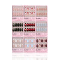 Nine sets of glamnetic Almond Joys press-on nails are arranged in a 3x3 grid, each box featuring almond-shaped nails in various colors and designs, such as glitter French tips, red, black, blue, nude, floral, and holiday patterns.