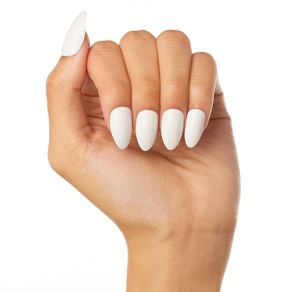 A hand with medium brown skin is shown in a fist, displaying long, almond-shaped glamnetic Angel press-on nails in glossy white, set against a plain white background.