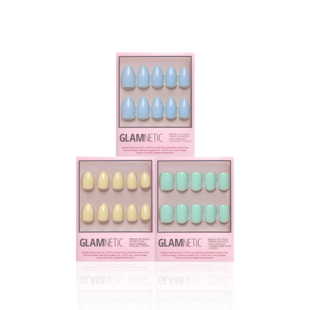 Three boxes of Glamnetics Anns Palette press-on nails in pastel blue, yellow, and green are arranged in a triangle on a white background. Each box shows glossy finish nails through a clear window—ideal for spring manicures.