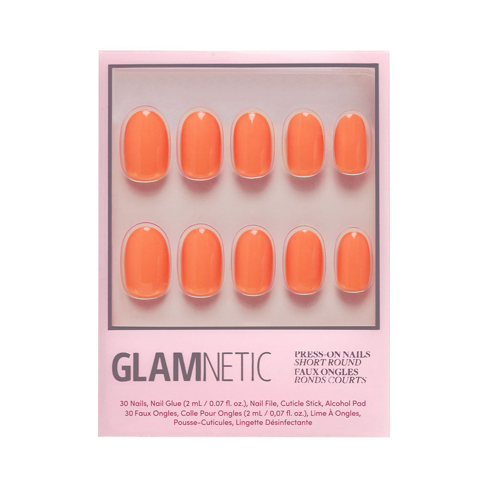 The Apricot press-on nails by glamnetic include 10 short, round orange nails on a pink card, plus nail glue, file, cuticle stick, and alcohol pad for easy application.