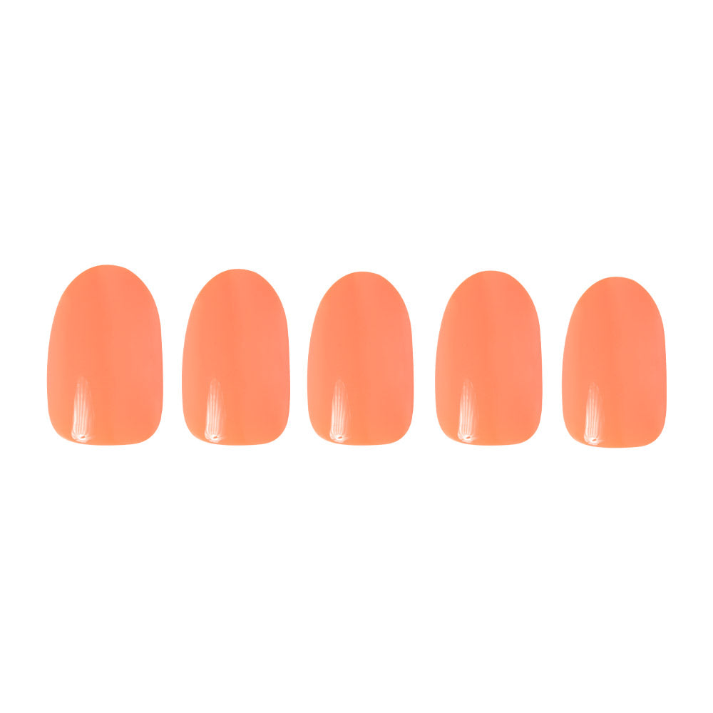 Five glossy peach and coral artificial nails from the glamnetic Apricot collection are arranged in a row on a white background, highlighting this vibrant nail set.