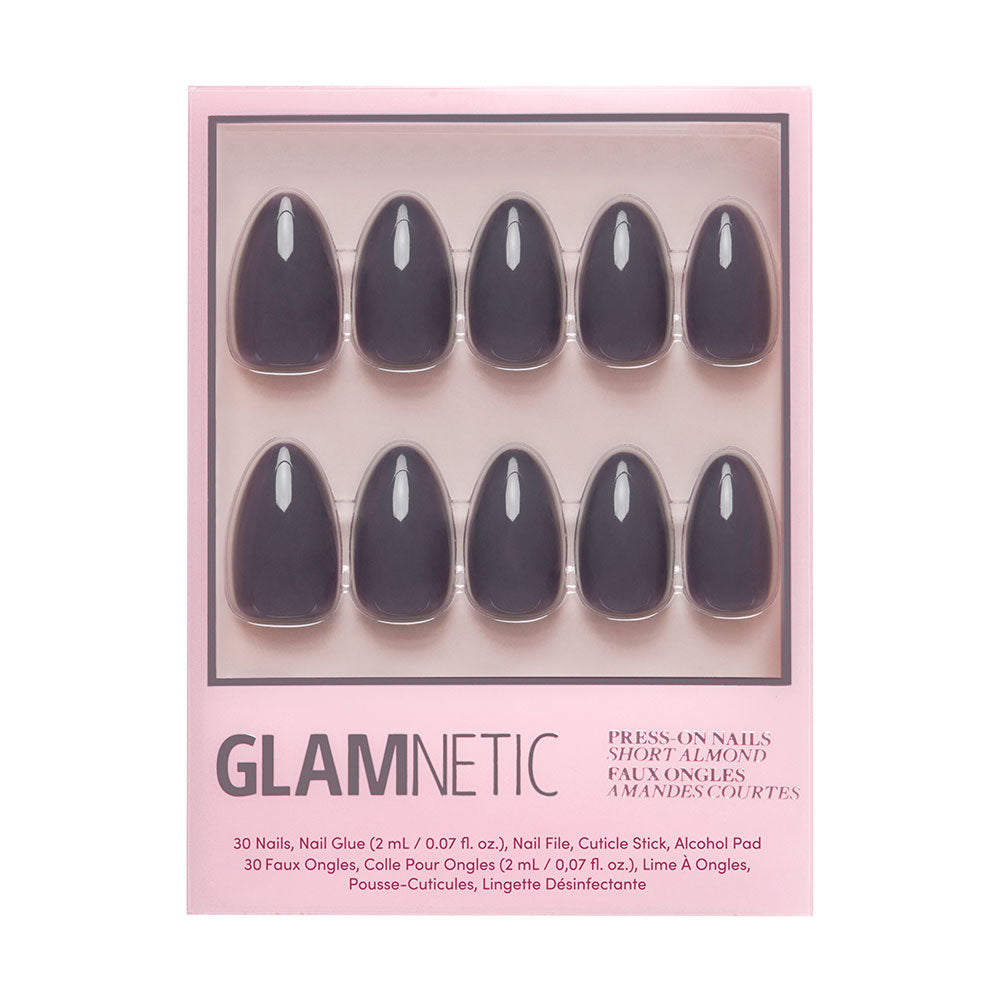 A box of glamnetic Ash Gray nails with 10 short, ash gray nails, nail glue, a cuticle stick, and an alcohol pad in pink packaging with black and metallic text.