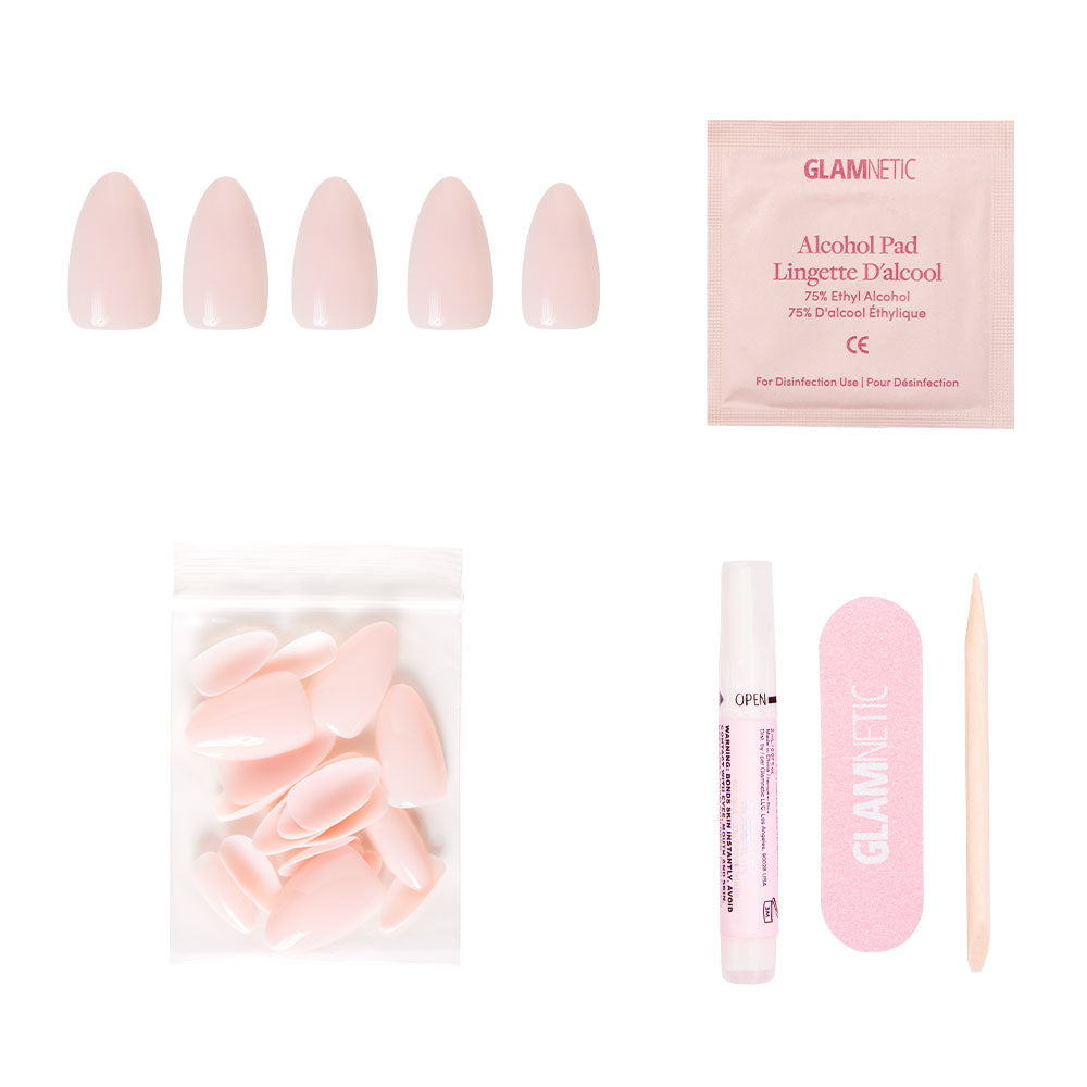 The glamnetic Ballet Pink set includes glossy short almond press-on nails, extra nails, nail glue, an alcohol pad, a pink nail file, and a wooden cuticle stick—displayed on a white background.