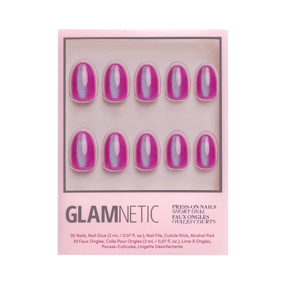 A box of glamnetic Berry Fizz press-on nails in a short oval shape, including ten shimmery pink nails with a velvet metallic finish, shown in clear packaging with product details at the bottom.