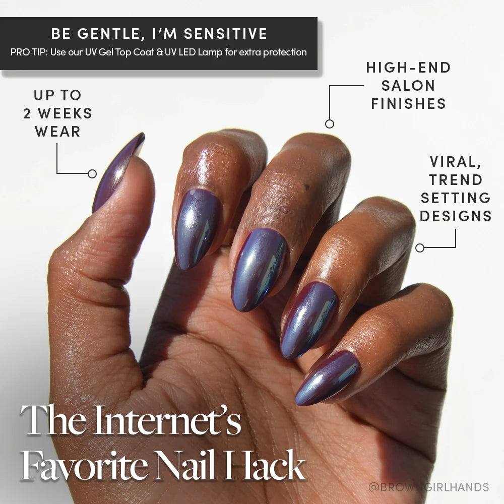 A hand with short almond glamnetic Burgundy Chrome nails in metallic purple is shown against a white background. These reusable press-ons deliver viral designs and a salon-quality finish for up to two weeks—the Internet’s Favorite Nail Hack.