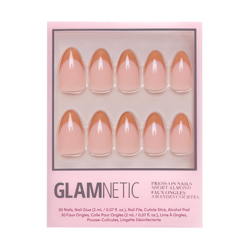 A box of glamnetic Café Crème reusable press-on nails in a short almond shape and nude pink shade. The set displays ten nails in packaging with cozy vibes, plus text listing the contents and instructions.