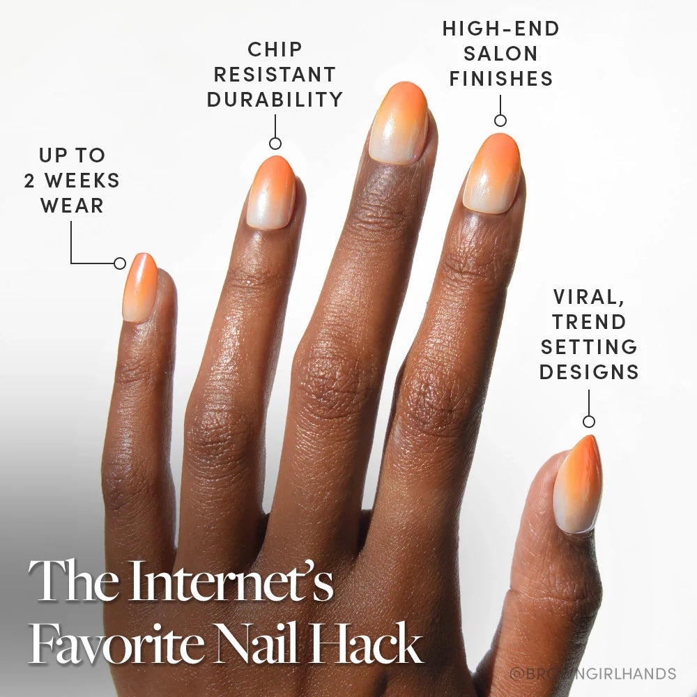 A hand with long almond-shaped nails in an orange and nude gradient design. Candy Corn by glamnetic offers up to 2 weeks wear, chip-resistant durability, and viral Halloween styles for a high-end salon finish.