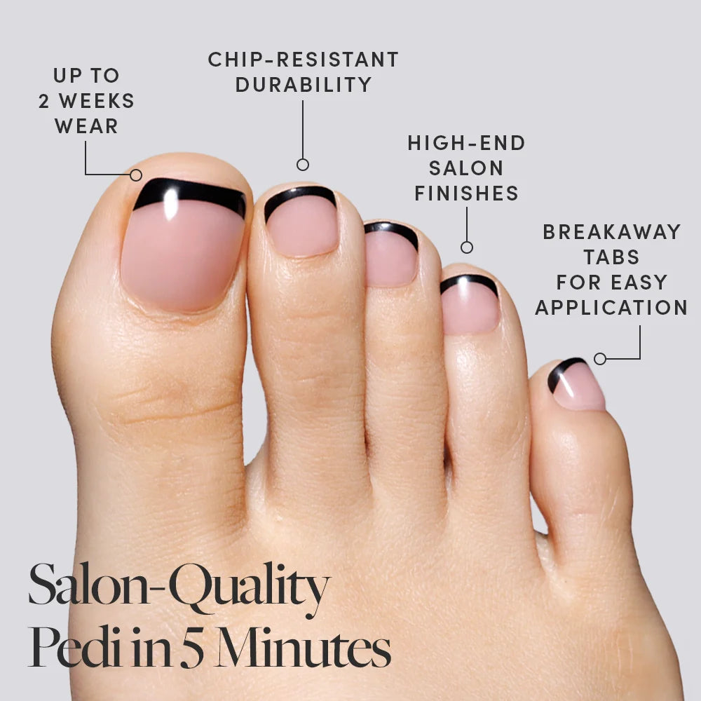 A foot in Glamnetic black French tip press-on toenails with labeled benefits including easy application and chip resistance.