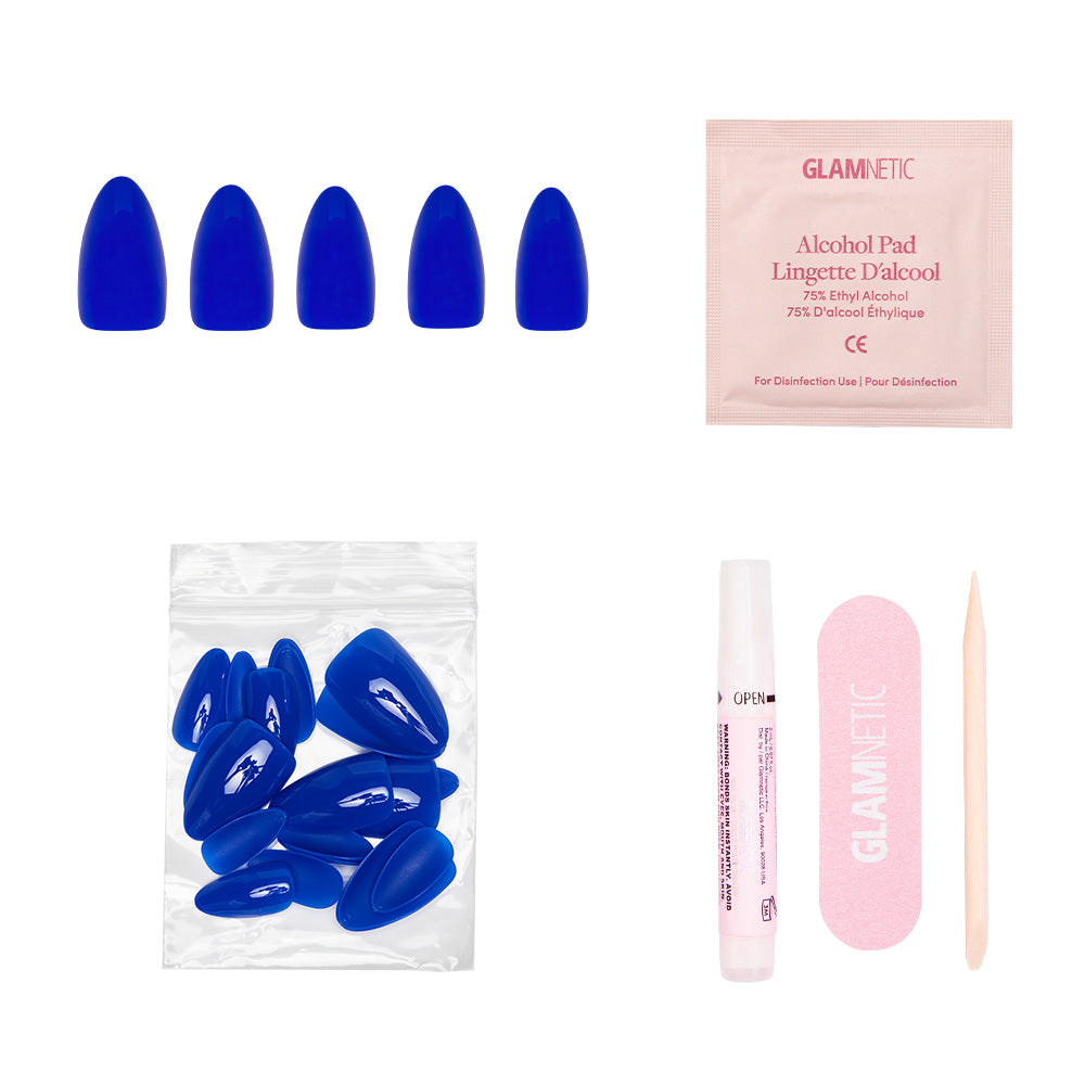 The glamnetic Cobalt Blue set features short almond nails, extra nails, an alcohol pad, nail glue, a pink file, and a cuticle stick—perfect for summer adventures—all arranged on a white background.