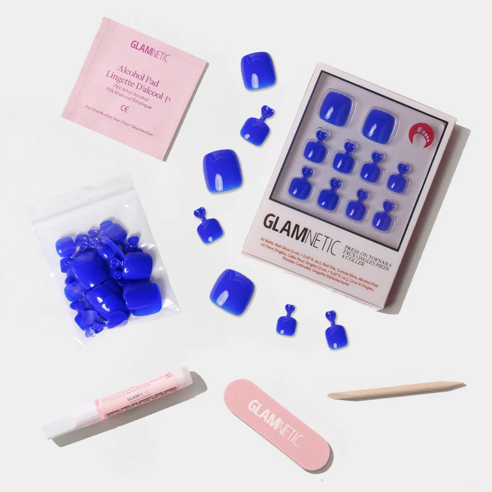 A flat-lay of the Glamnetic bright cobalt blue press-on toenail kit with all included application tools.