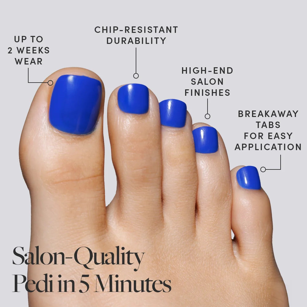 A close-up of blue Glamnetic press-on toenails on a foot, with icons describing their lasting and salon-quality perks.