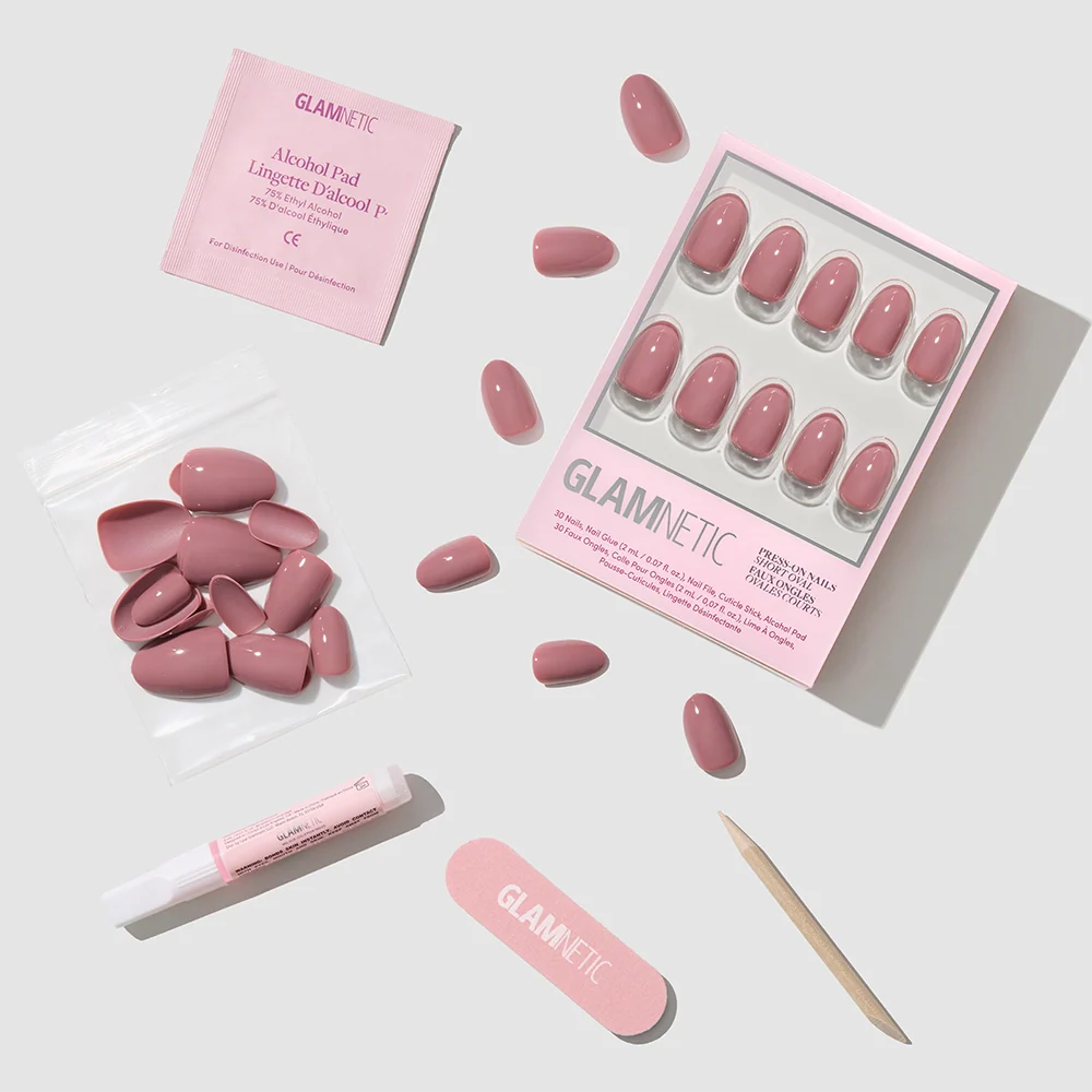 The Fall Mauve Nail Set by glamnetic features pink press-on nails with trendy fall designs, plus a nail file, cuticle stick, alcohol pad, nail glue, and extra nails—all neatly displayed on a light gray background.