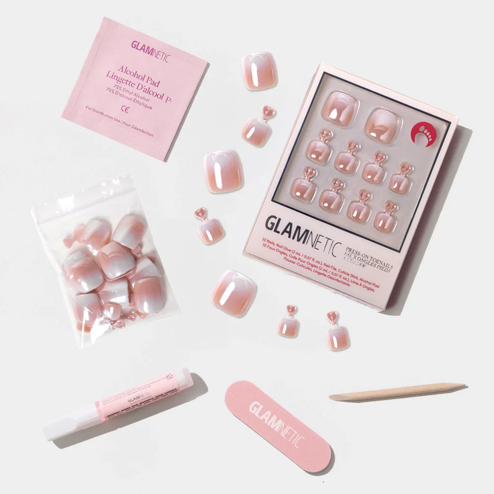 A flat-lay of the Glamnetic iridescent pink ombré press-on toenail kit with all included tools and accessories.