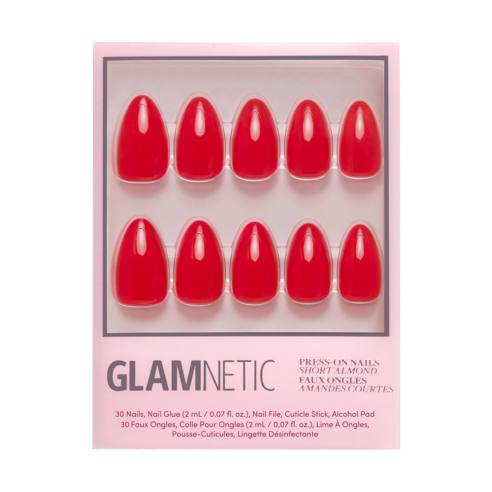 A package of glamnetic Fiery Red press-on nails in a bold summer color, arranged in two rows inside a pink box for short almond shapes. Includes nail glue and alcohol pad as listed on the packaging.