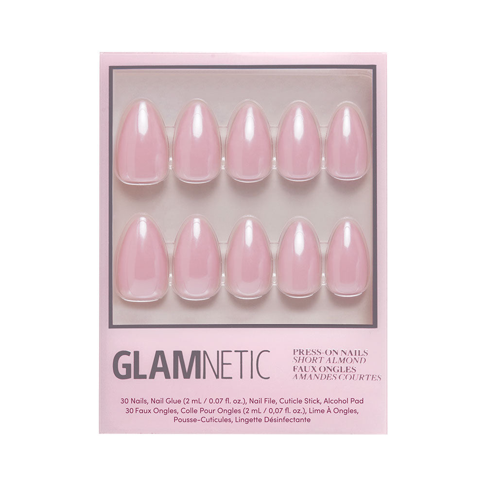 The First Kiss Nail Set by glamnetic includes 30 glossy blush pink short almond press-on nails, nail glue, file, cuticle stick, and alcohol pad for a flawless at-home manicure.
