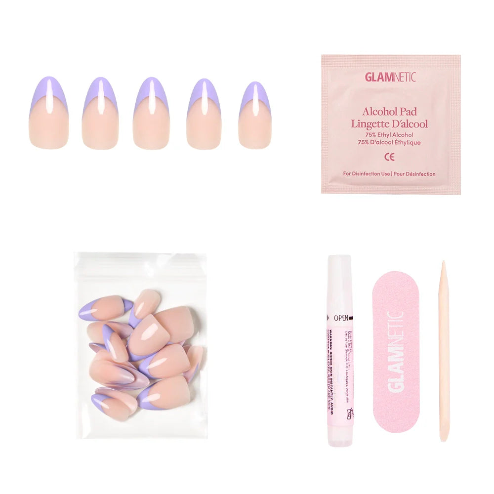 The glamnetic French Lilac Press-On Nails set features short almond nails with pastel purple tips, an alcohol pad, spare nails in a bag, nail glue pen, pink file, and cuticle stick—all displayed on a white background.