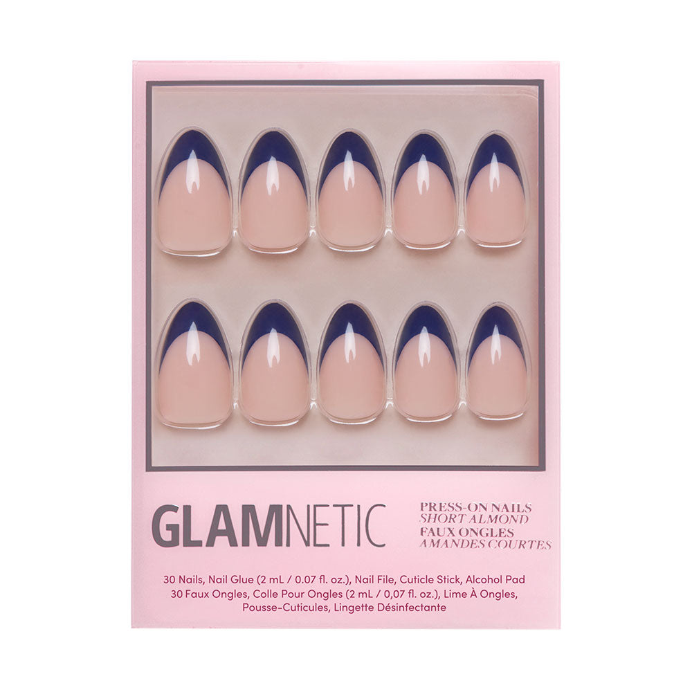A box of glamnetic French Riviera Nail Set comes with short almond nails featuring a nude base and navy French tip, plus nail glue, nail file, cuticle stick, and alcohol pad.