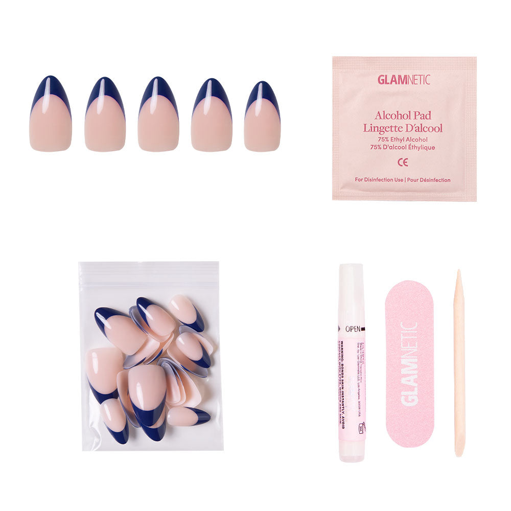 The French Riviera by glamnetic includes navy French tip short almond nails, extra nails, an alcohol pad, nail glue, a pink nail file, and a wooden cuticle stick—all set against a white background.