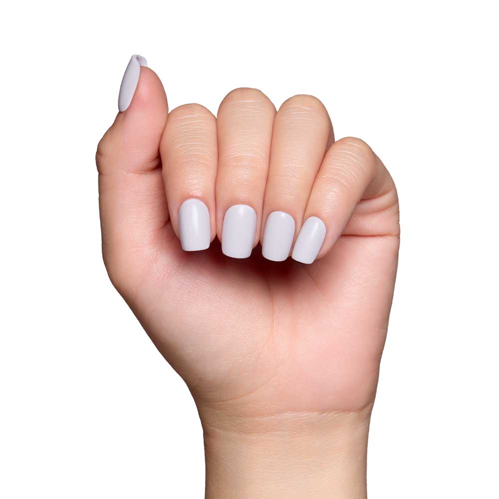 A hand with neatly manicured squoval nails painted in glamnetics Lilac Gray is shown against a white background. The slightly curled fingers highlight the pastel shade and glossy finish of these stylish nails.