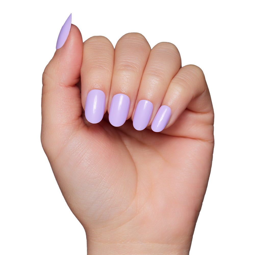 A hand with neatly manicured nails, featuring the glossy light lavender Lilac nail set by glamnetic, is displayed against a white background.