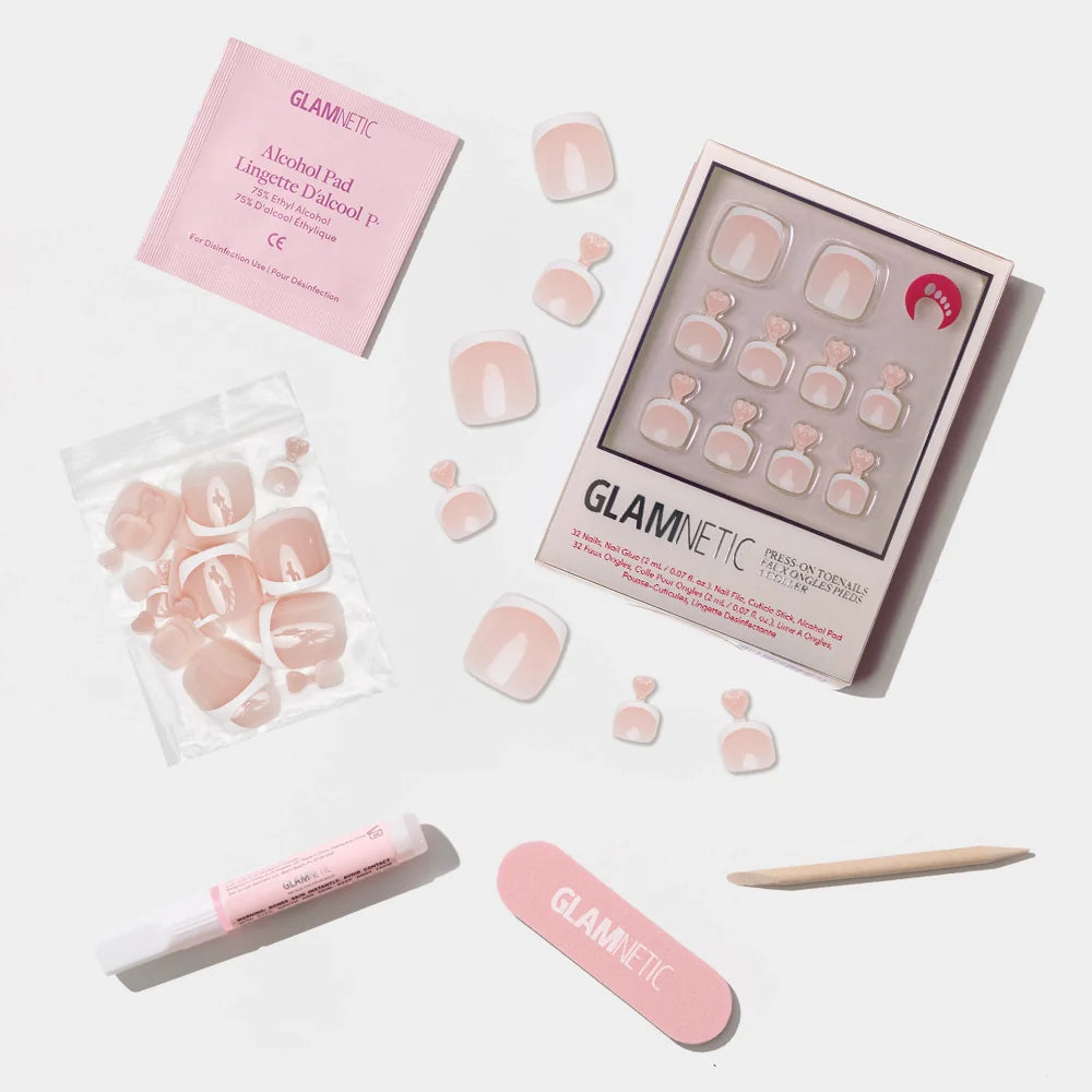 A flat-lay of the Glamnetic soft nude pink press-on toenail kit featuring a glossy solid color and full prep set.
