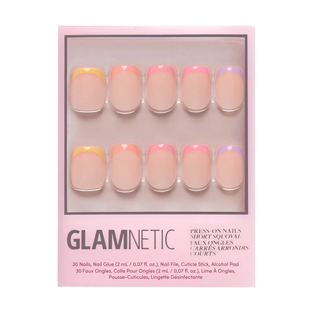 A box of glamnetic Macarons Press-On Nails includes 10 short, square nails with pastel French tips in yellow, pink, orange, and purple. The pink packaging displays product details at the bottom.